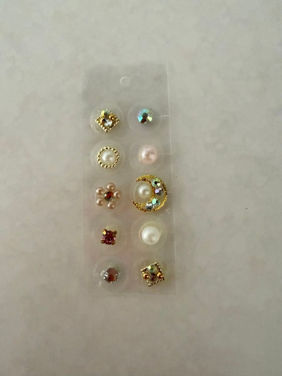 Ear acupressure jewelry, 10 pearls with a gold design.