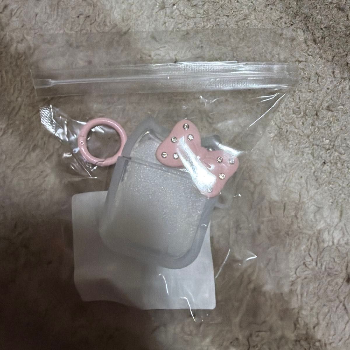 适用于 AirPods 的透明保护壳，附带粉色蝴蝶结挂饰