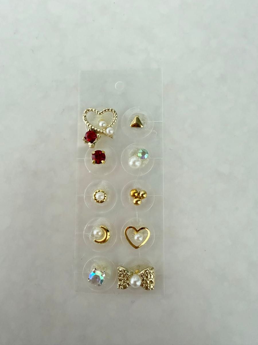 10-piece ear acupressure jewelry set: hearts, ribbons, and stones.