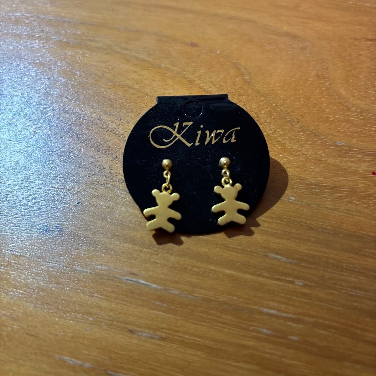 Kiwa bear-themed earrings, gold-colored, with a dangling animal design