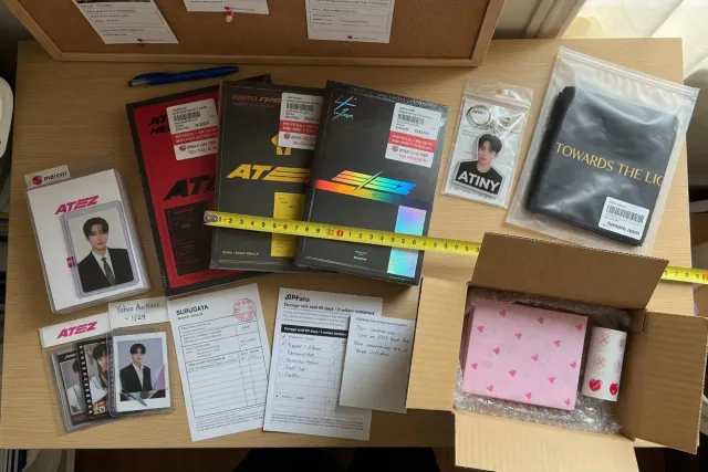 Several boxed ATEEZ albums, photocard sleeves, and small accessories prepared together for international shipping