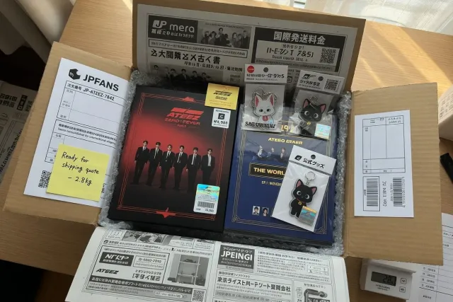 Packed ATEEZ merchandise parcel with albums and keychains ready for worldwide shipping from Japan
