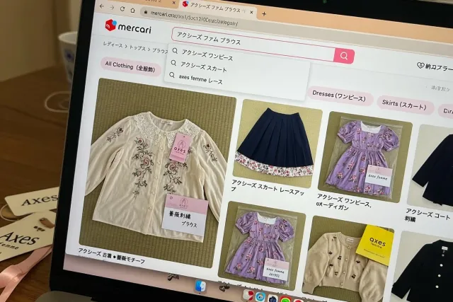 Axes femme clothing listings on a Japanese marketplace, including blouses, skirts, dresses, and cardigans