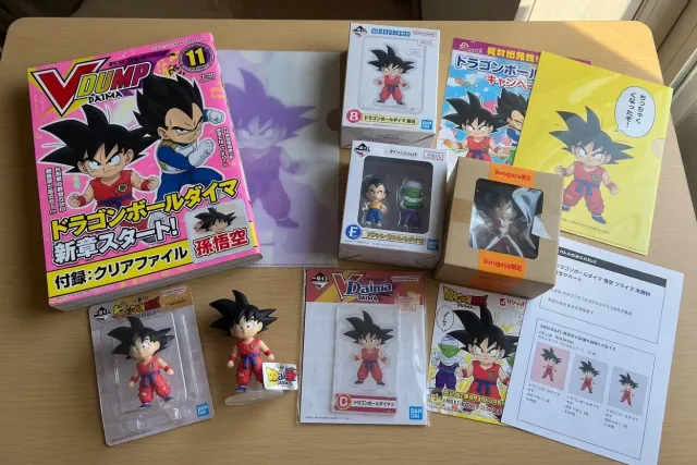 Dragon Ball Daima merchandise display with Goku mini figures, Japanese magazines, and boxed collectibles