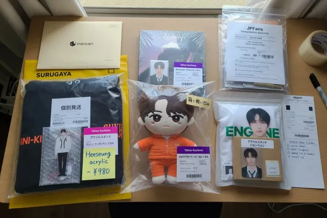 Several ENHYPEN merchandise orders including plush, albums, apparel, and acrylic stands prepared for consolidation