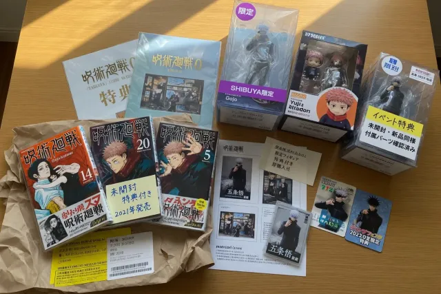 Jujutsu Kaisen manga volumes and character figures displayed with limited Japanese goods
