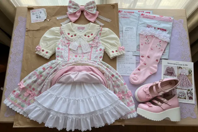 Lolitas fashion coordinate from Japan with a printed jumperskirt, blouse, petticoat, headbow, socks, and platform shoes