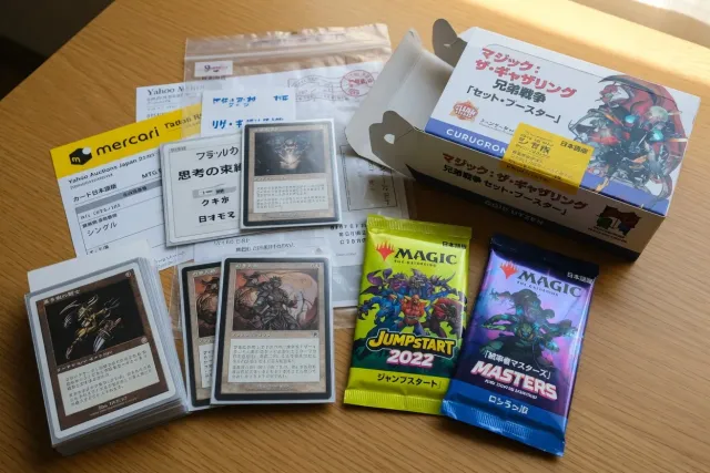 Japanese editions of Magic The Gathering singles and sealed booster products on a collector desk