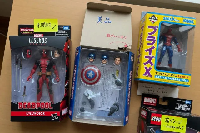 Close-up of Marvel Legends figures and Japanese Marvel prize figures in original boxes, showing packaging condition