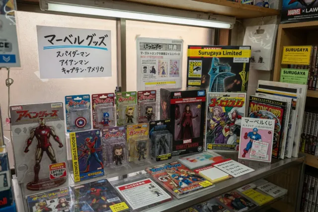 Japanese Marvel collectibles display featuring MCU figures, comics, LEGO sets and character merchandise in a hobby shop