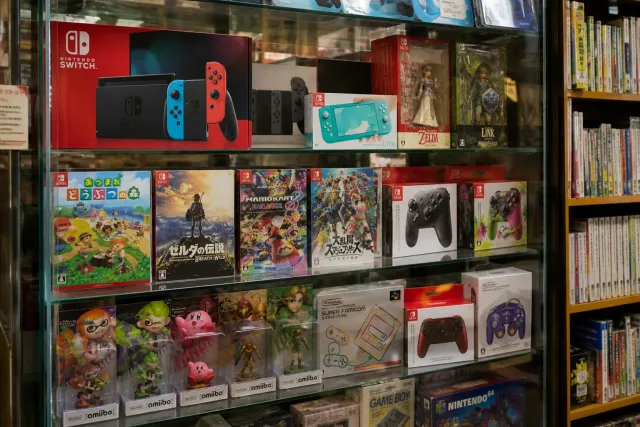 Japanese Nintendo Switch consoles, boxed games, controllers, and character collectibles arranged in a game shop display