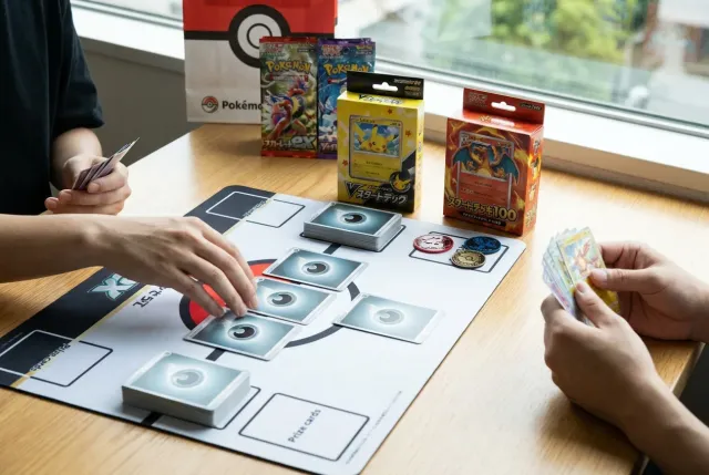 A playmat showing the setup for a Pokémon TCG match with deck and Prize cards