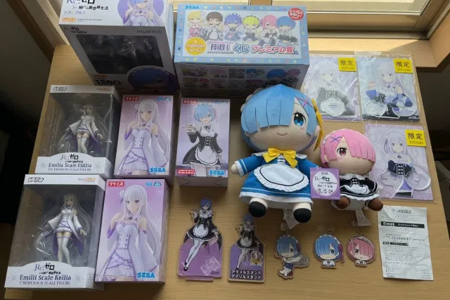 A Japanese Re:Zero merchandise display with Emilia scale figures, Rem prize figures, plush toys, acrylic stands, and boxed character goods