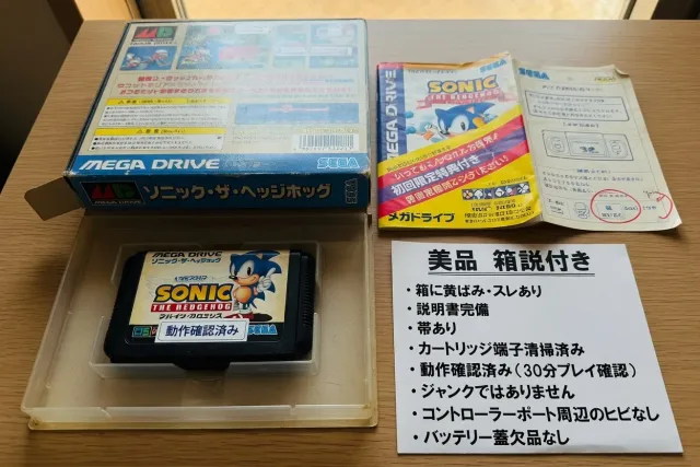 Close view of a used SEGA Mega Drive game case, cartridge, manual and Japanese condition description