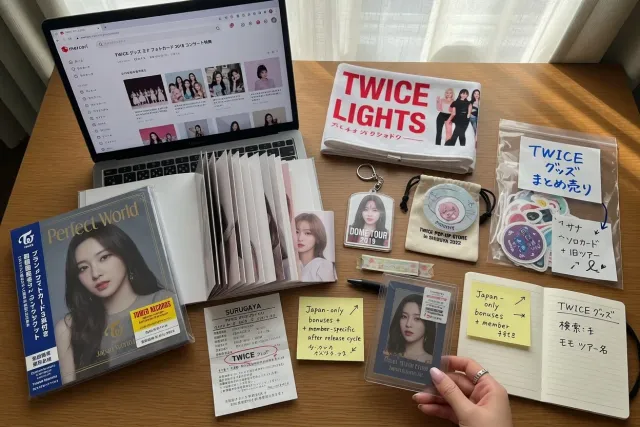 A collector comparing TWICE merchandise from Japan, including Japanese albums, photocards, and concert goods