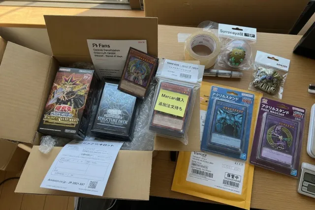 Yu-Gi-Oh! cards, sealed decks, and acrylic stands packed together for worldwide shipping from Japan